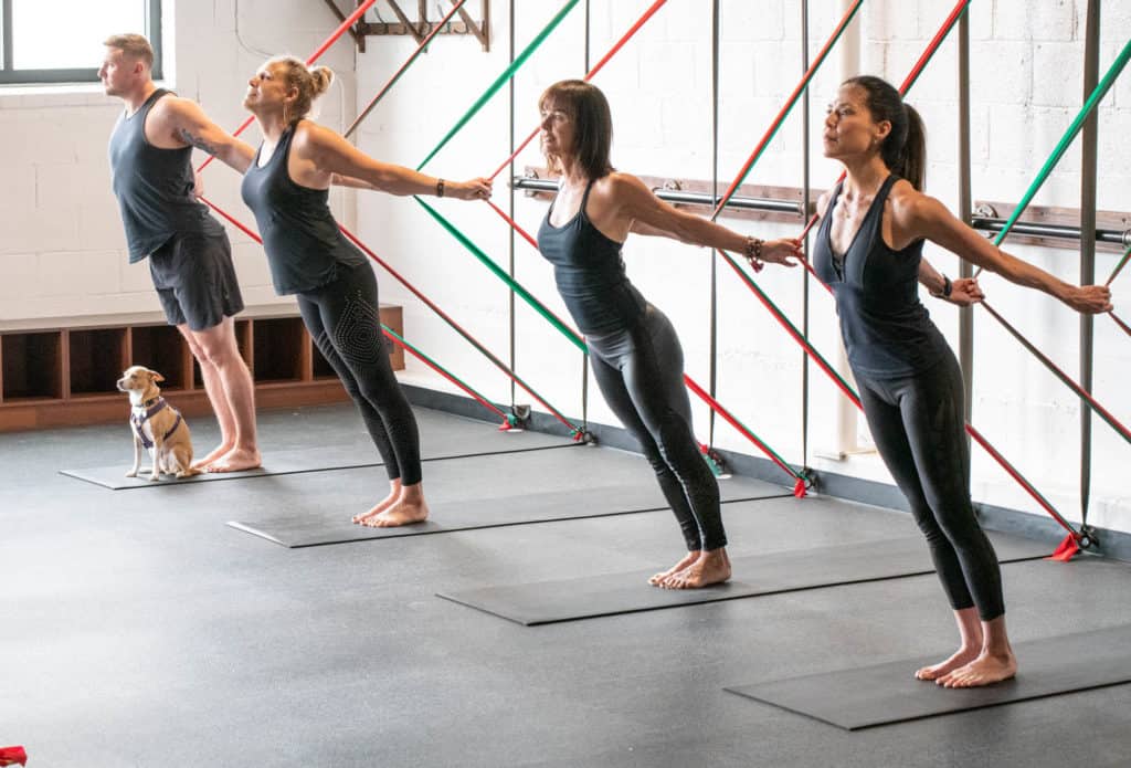people stretching at BOARD30 studio in black workout attire after returning to the gym